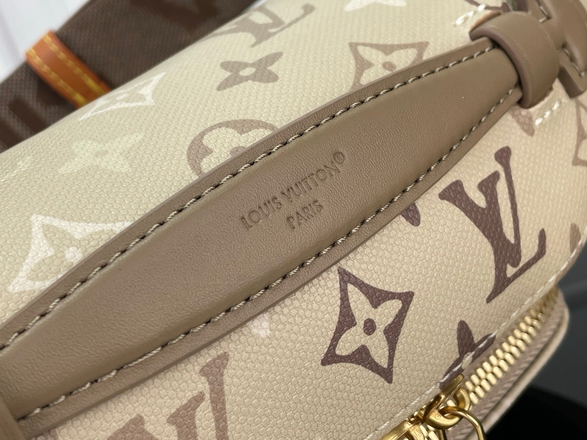 Louis Vuitton monogram belt bag detail with brown leather strap and stitched trim