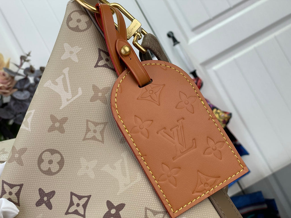 Beige monogram bag with tan leather luggage tag and gold clasp