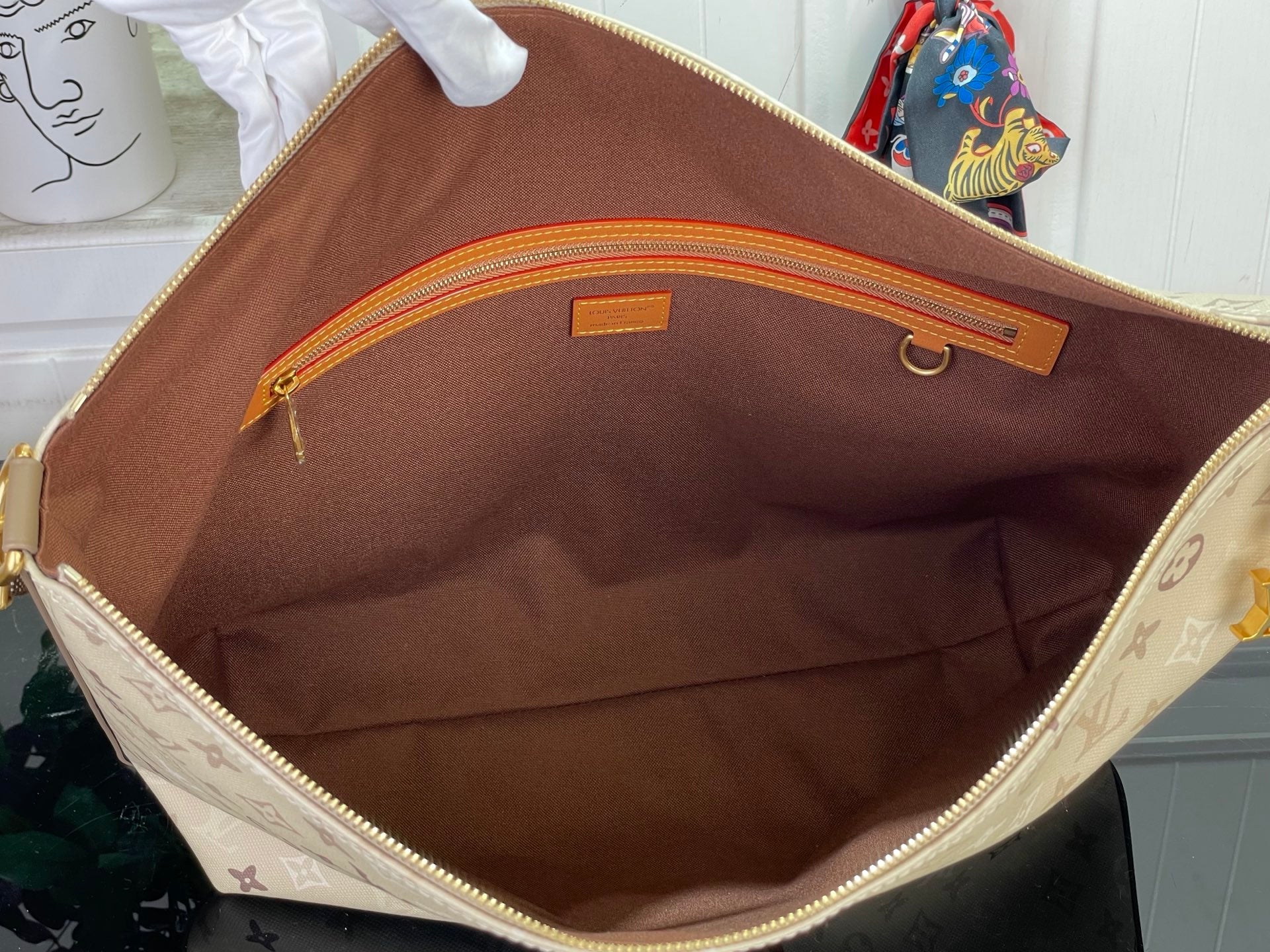 Beige monogram bag interior with brown lining and zippered pocket