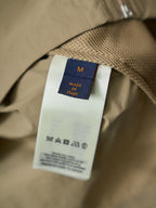 Louis Vuitton shirt label tag: size M and “Made in Italy” on tan fabric