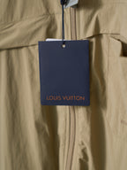 Louis Vuitton price tag hanging from light tan shirt zip front