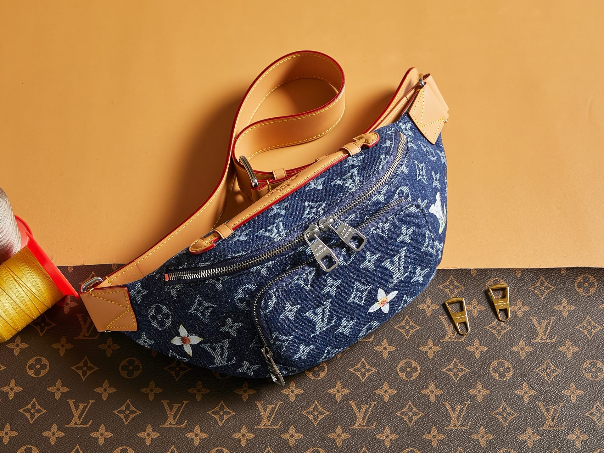 Louis Vuitton denim monogram crossbody bag with tan leather trim and zip pocket