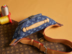 Louis Vuitton denim monogram crossbody bag with tan leather handle and front zip
