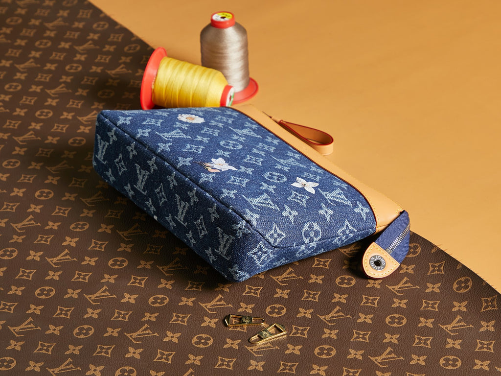 Louis Vuitton monogram pouch with blue fabric, tan strap, and zipper closure