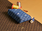 Louis Vuitton monogram pouch with blue fabric, tan strap, and zipper closure