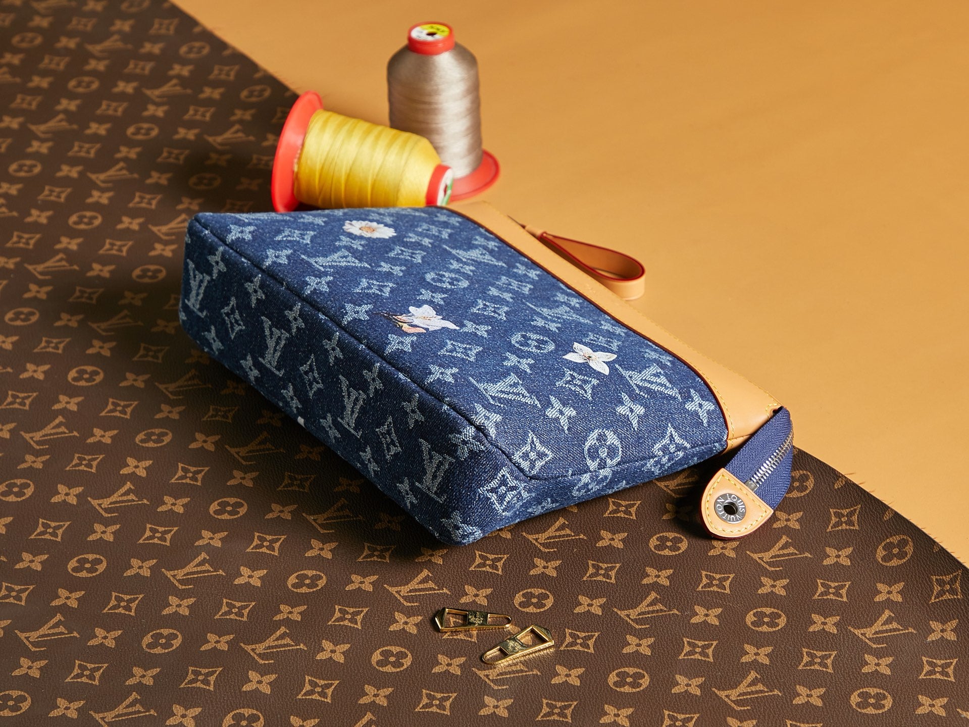 Louis Vuitton monogram pouch with blue fabric, tan strap, and zipper closure