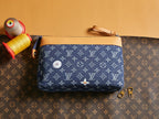 Louis Vuitton monogram pouch with blue canvas, tan wrist strap, and zipper top