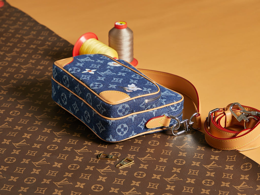 Louis Vuitton blue monogram crossbody bag with tan leather strap and zipper