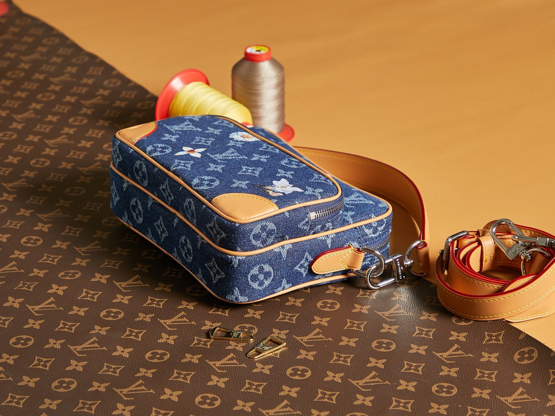 Louis Vuitton blue monogram crossbody bag with tan leather strap and zipper