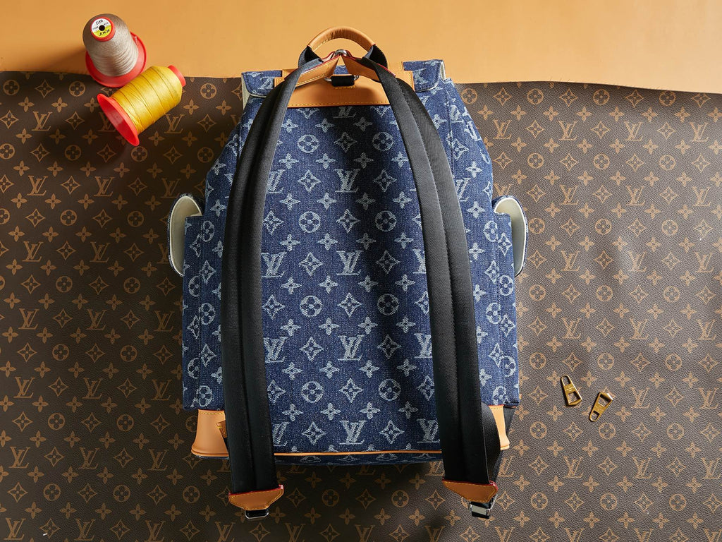 Blue monogram duffel bag with black side straps and tan leather base