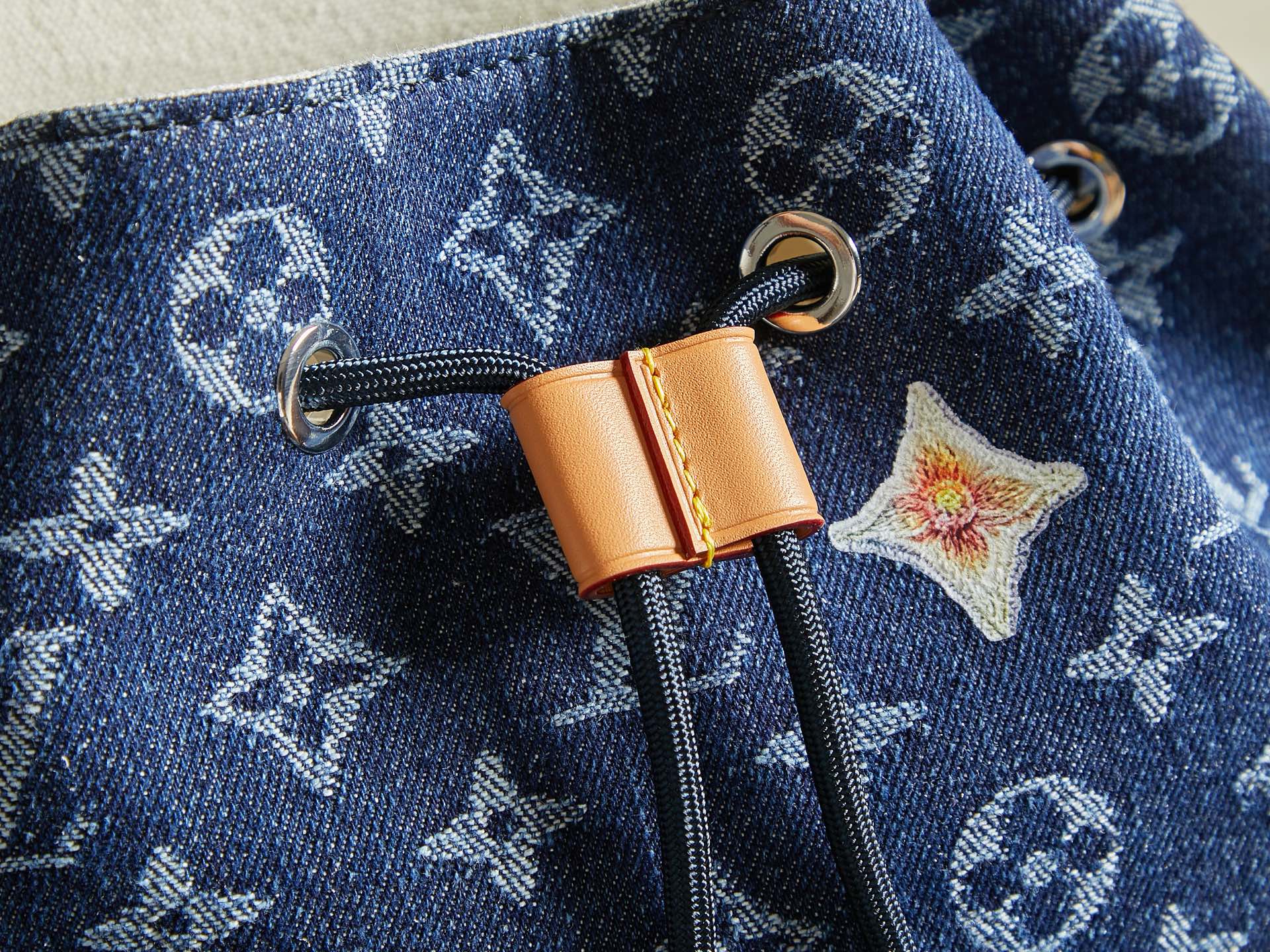 Close-up of duffel bag zipper pull with tan leather tab and star charm