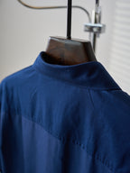 Dark blue shirt with high collar and subtle shoulder yoke