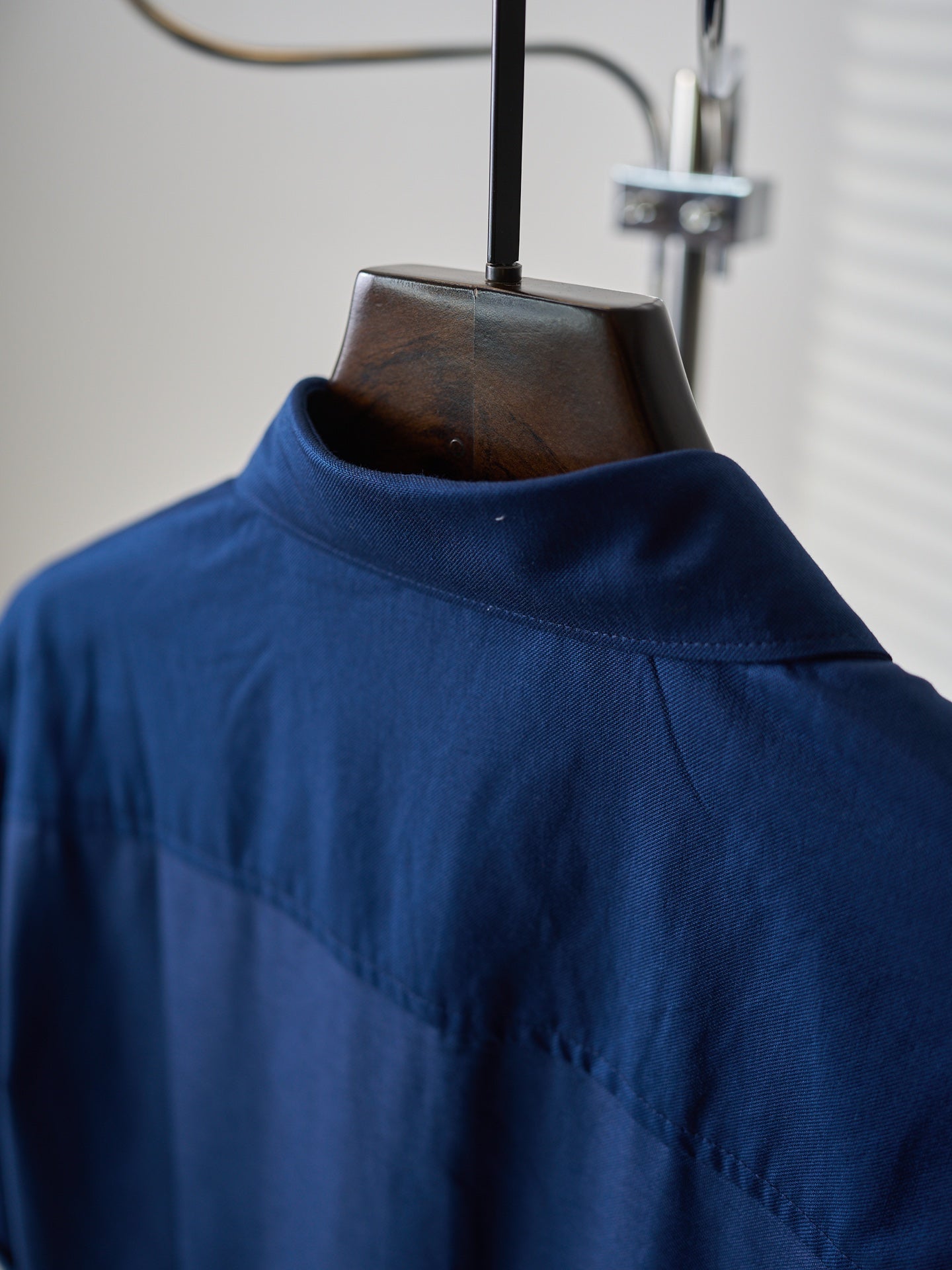 Dark blue shirt with high collar and subtle shoulder yoke
