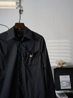 Fendi dark long jacket close-up of chest pocket and small yellow logo detail
