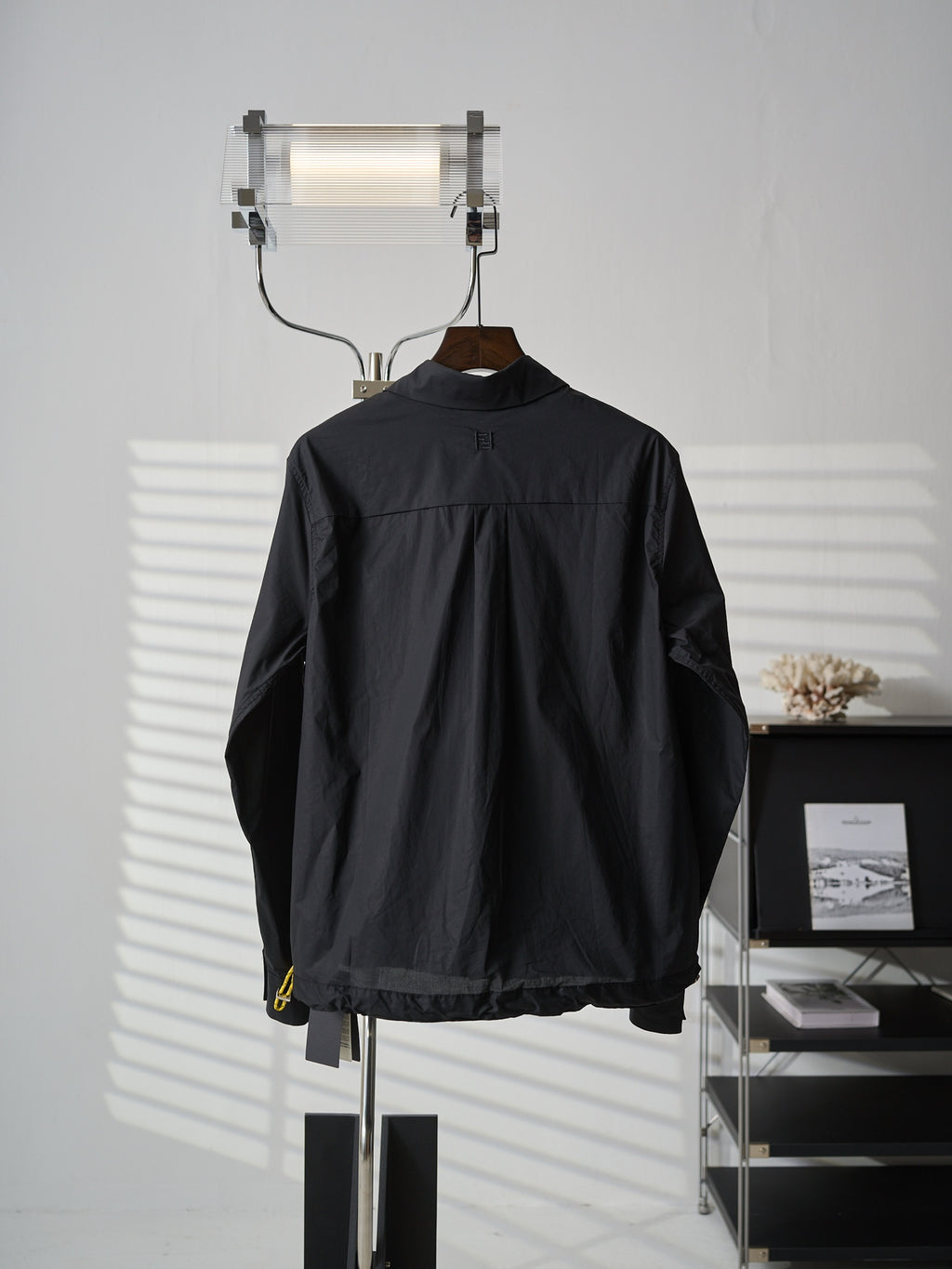 Fendi dark long jacket back view with stand collar and small yellow logo detail