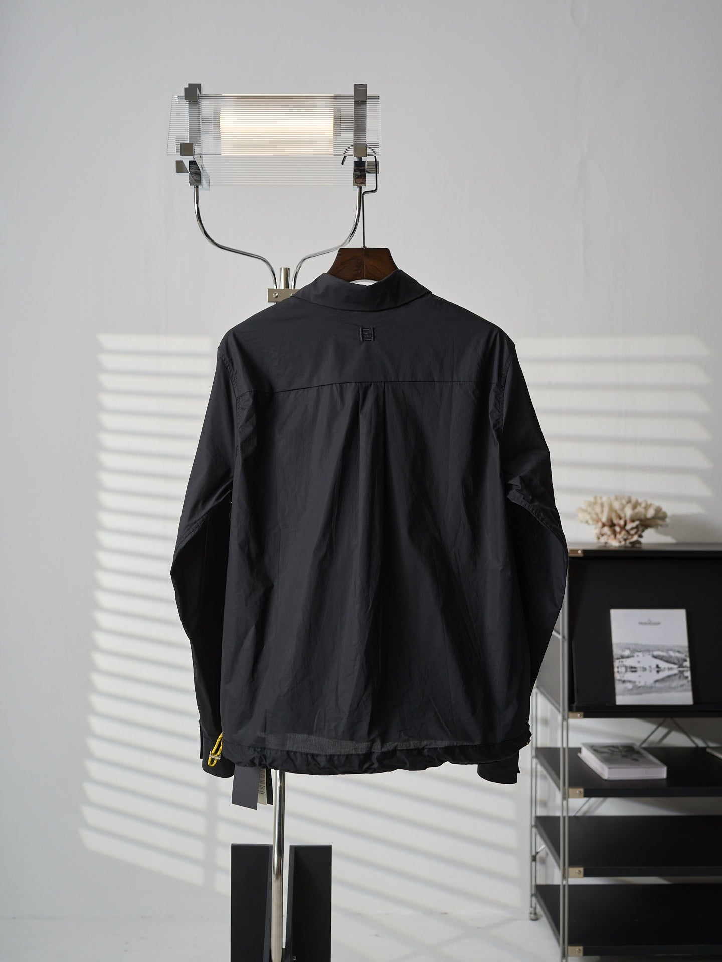 Fendi dark long jacket back view with stand collar and small yellow logo detail