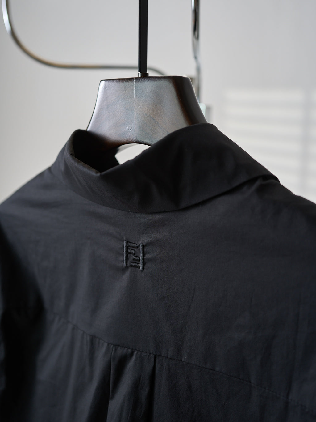 Fendi dark long jacket close-up of high neck and small logo embroidery