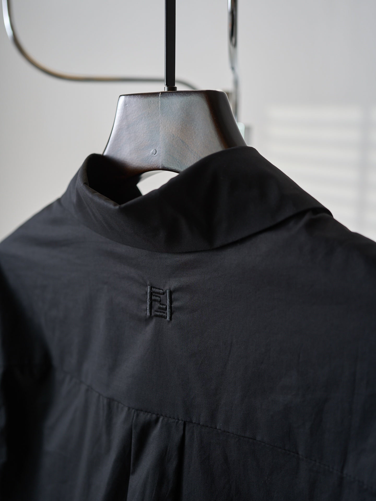 Fendi dark long jacket close-up of high neck and small logo embroidery