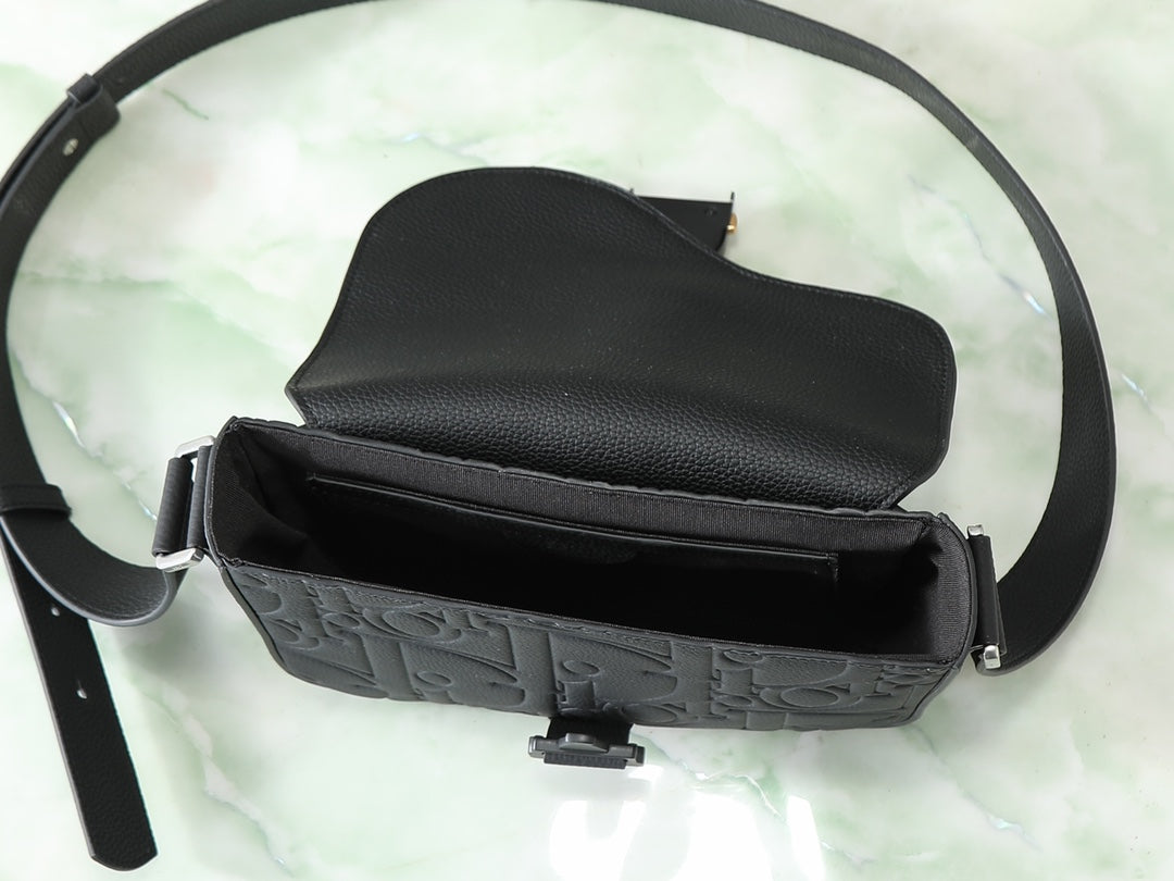 Dior black crossbody bag open with embossed front panel and crossbody strap