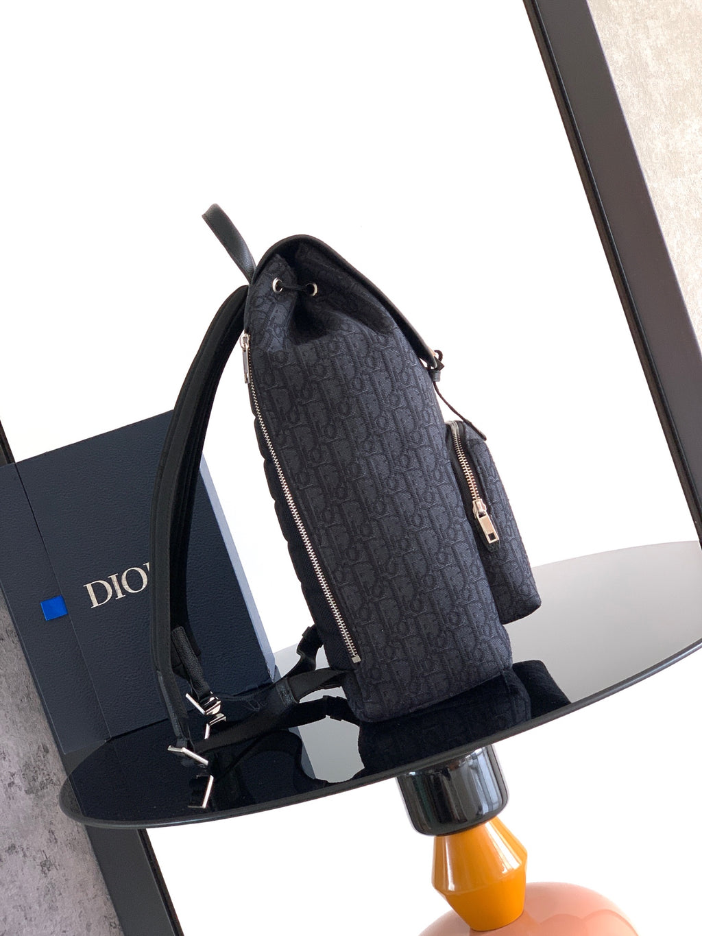 Navy Dior backpack side view with shoulder straps and zipper pocket