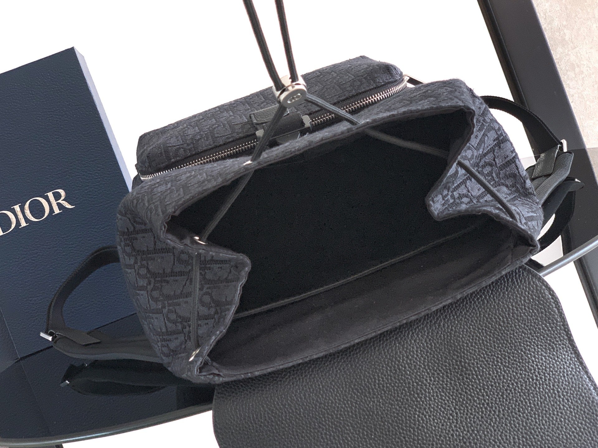 Open-top Dior bag showing dark interior and zipper opening