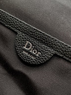 Black leather Dior label reading Made in Italy on strap tab