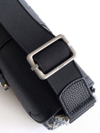 Dior bag hardware close-up with black leather strap and silver buckle
