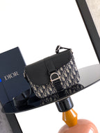 Dior crossbody bag with navy and beige logo canvas flap, black leather strap
