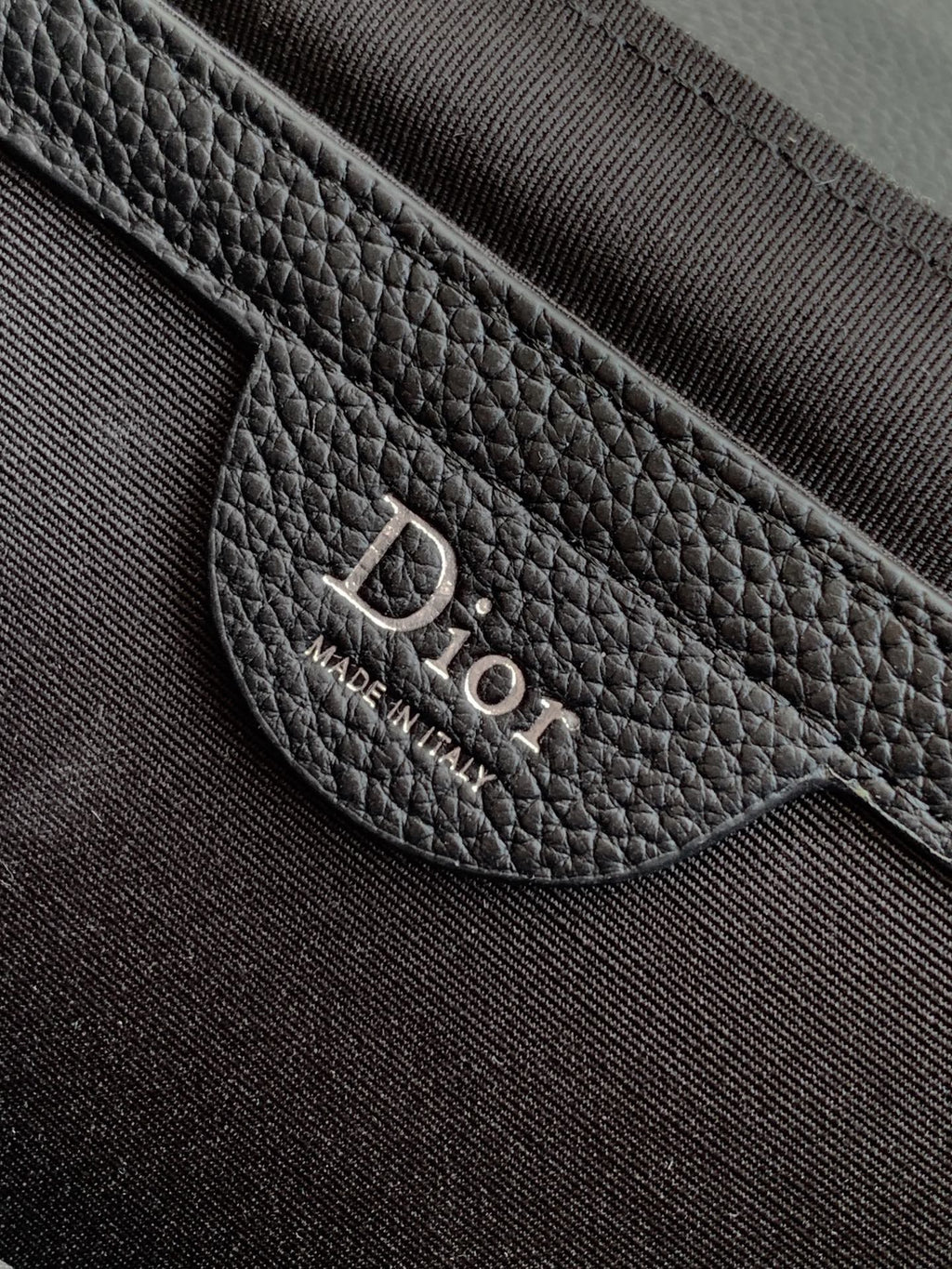 Dior bag leather patch with 'DIOR' text and 'MADE IN ITALY'