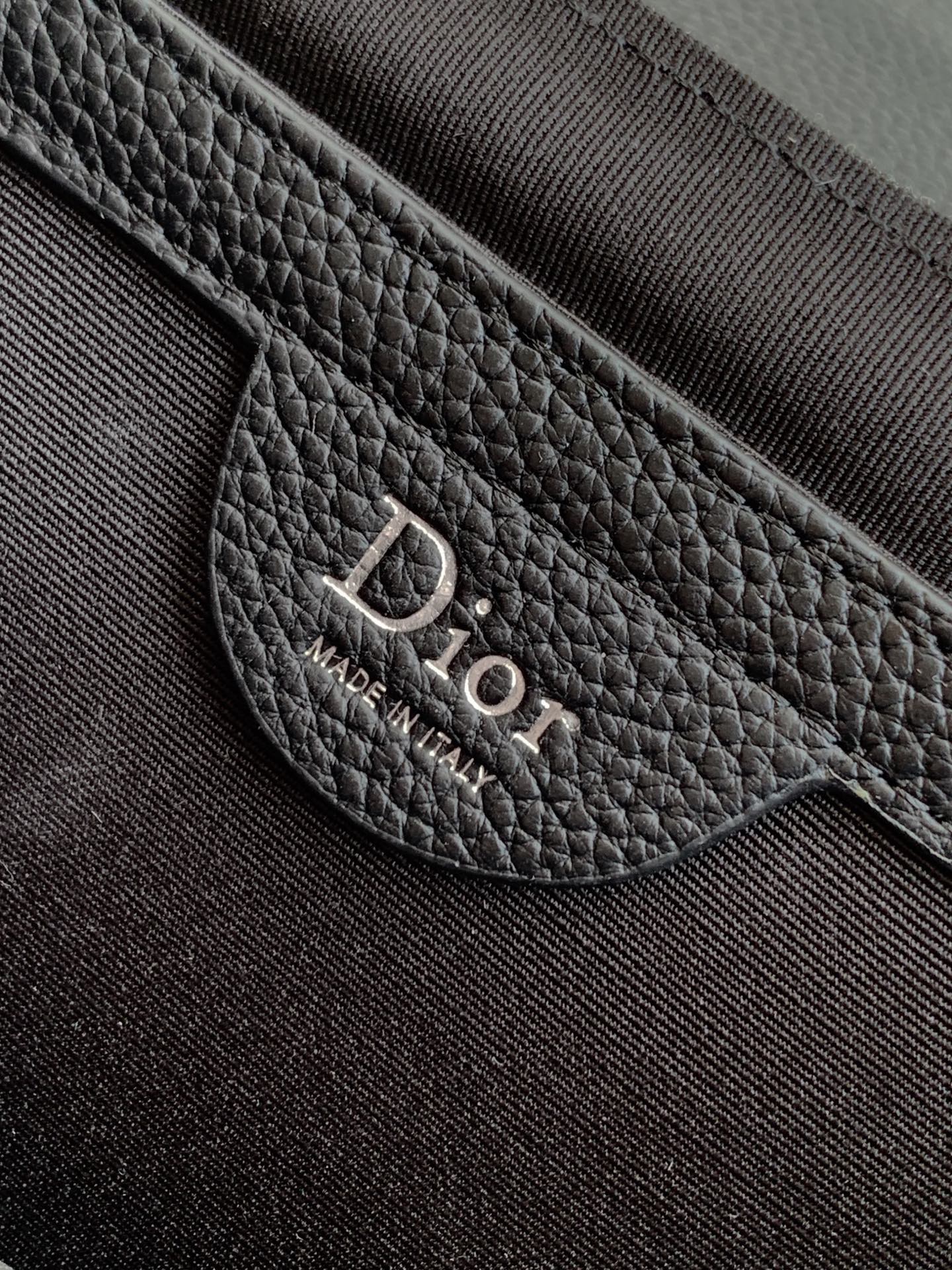 Dior bag leather patch with 'DIOR' text and 'MADE IN ITALY'