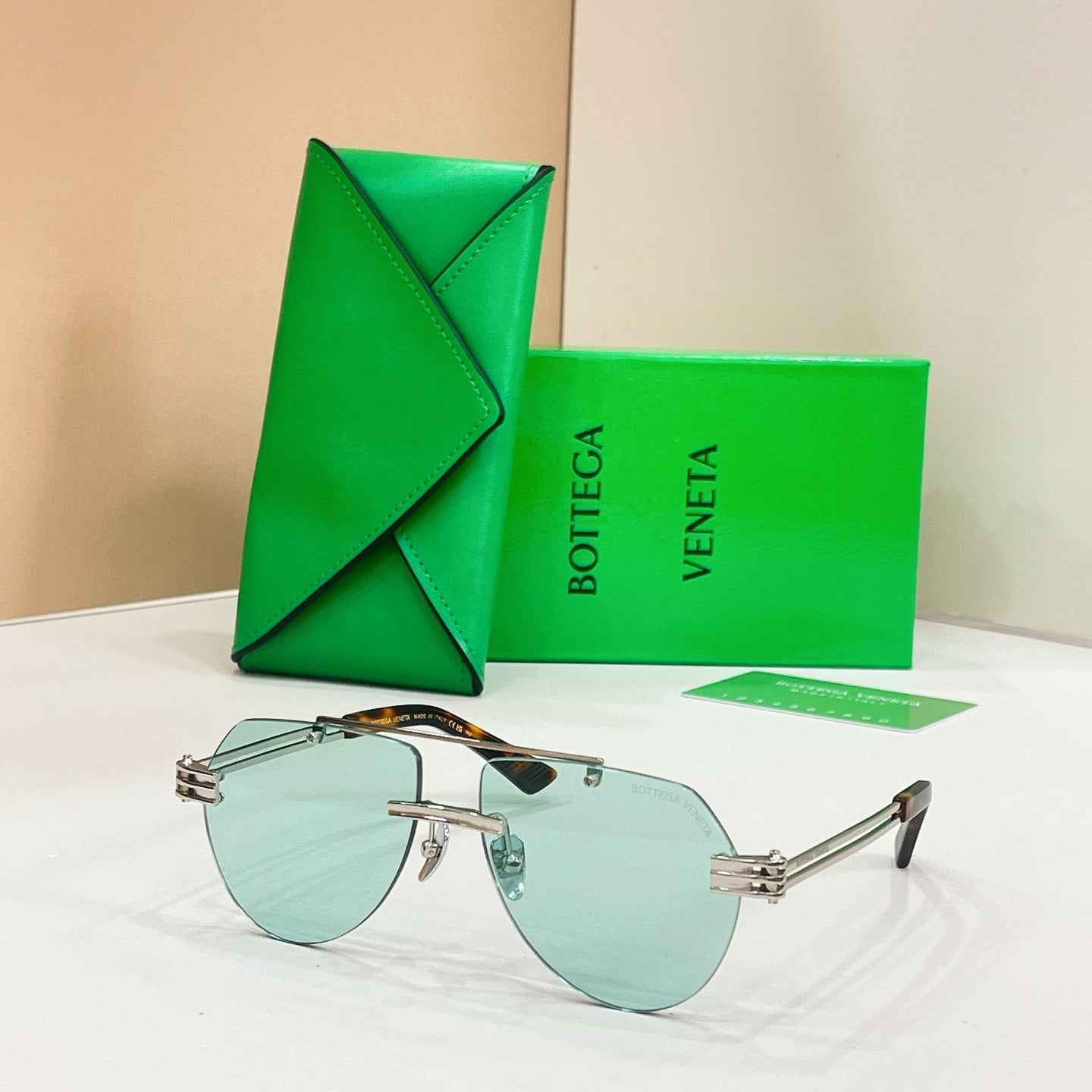Silver metal sunglasses with light blue lenses and slim rectangular frames