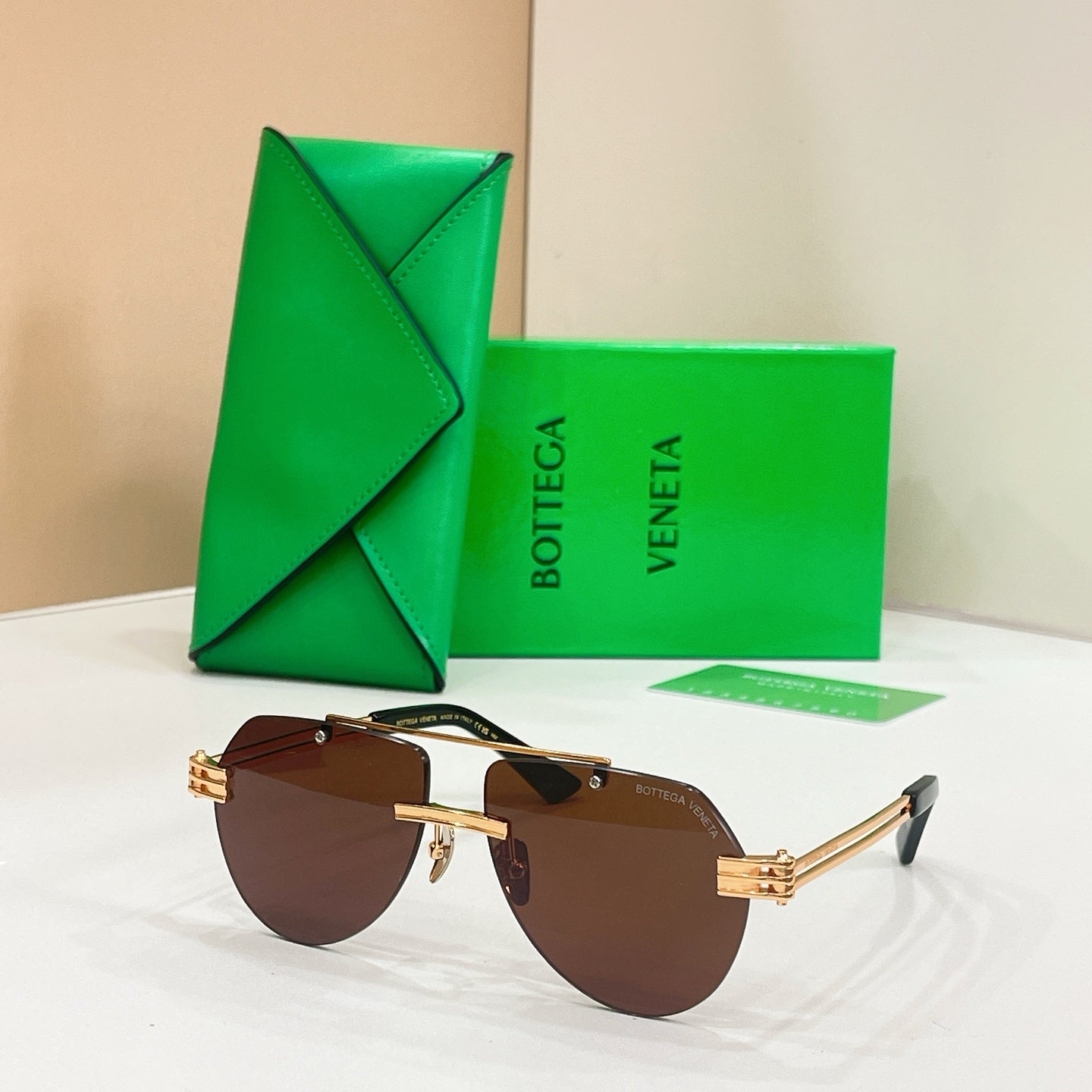 Gold metal sunglasses with dark brown lenses and slim rectangular frames