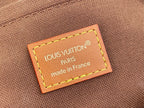 Brown leather label on beige monogram bag reading "Louis Vuitton" and "made in France".