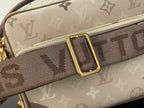 Beige monogram shoulder strap with gold buckle and repeated logo pattern.
