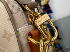 Beige monogram bag with gold-tone hook clasp and brown leather strap detail.