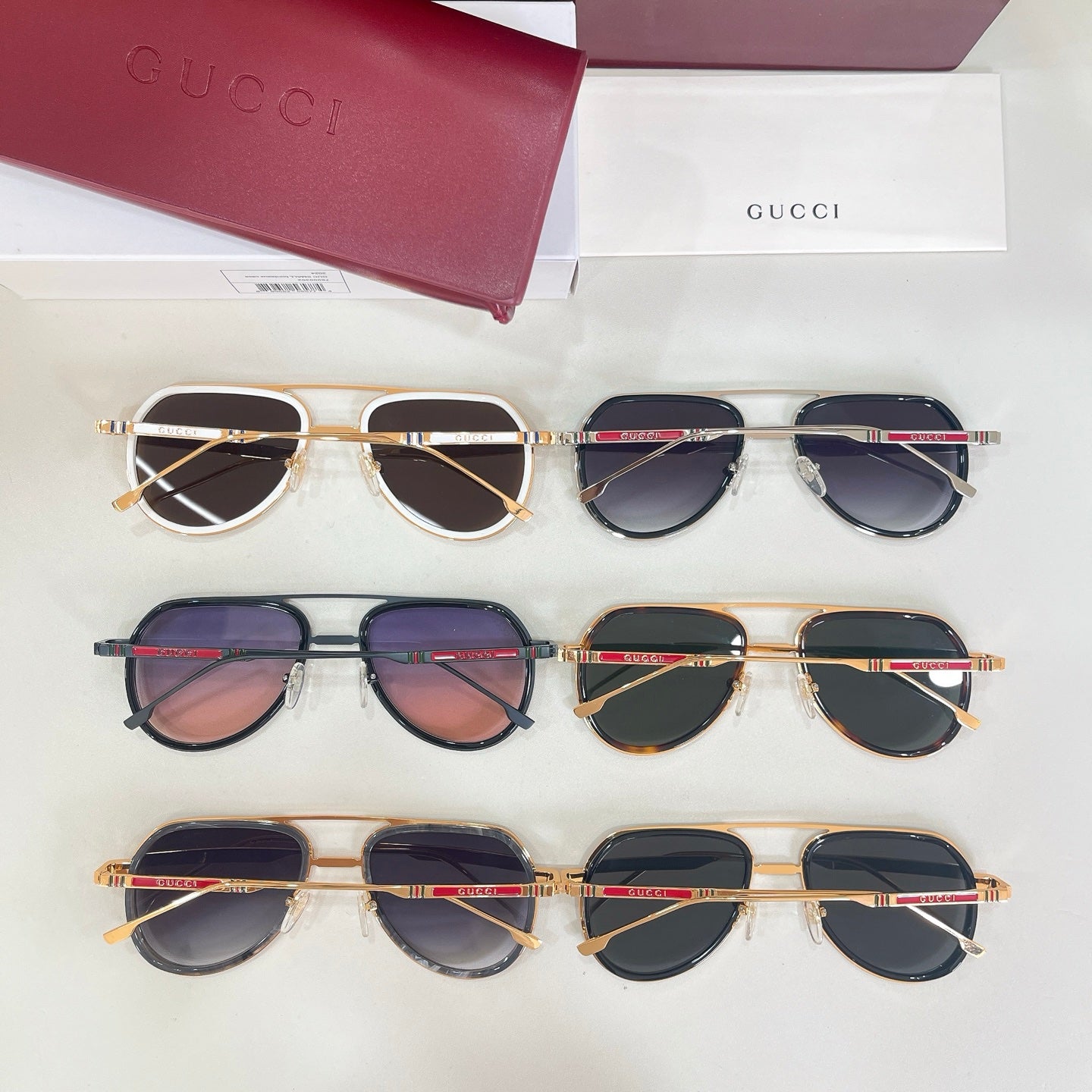 Multiple Gucci sunglasses laid out, assorted frames with dark lenses in rows