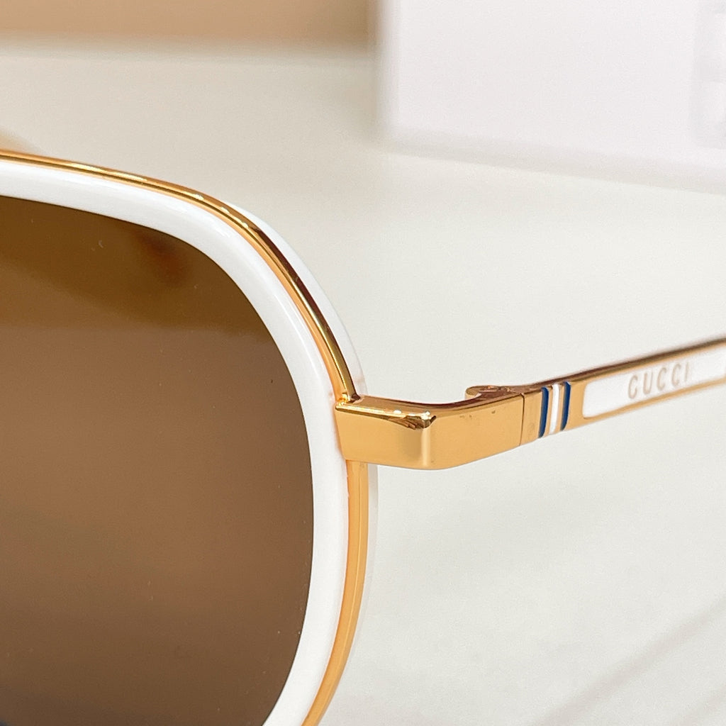 Gucci sunglasses temple detail with gold-tone frame and multicolor stripe branding