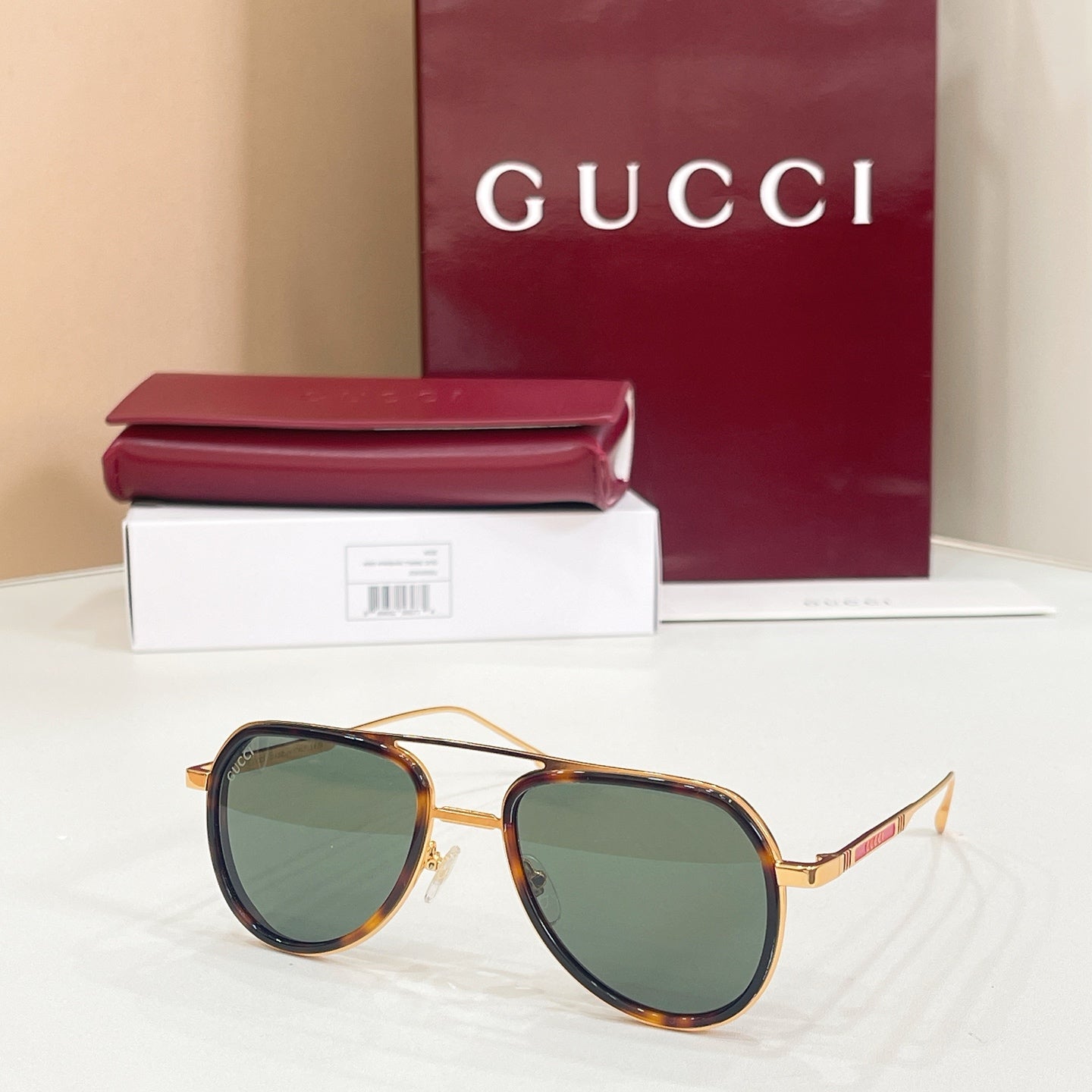 Gucci sunglasses with tortoiseshell frame, gold-tone details, and green-tinted lenses