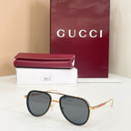 Gucci sunglasses with navy frame and dark lenses, gold-tone bridge