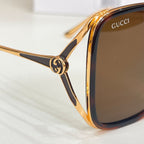 Gucci sunglasses close-up, gold-tone frame with brown lenses