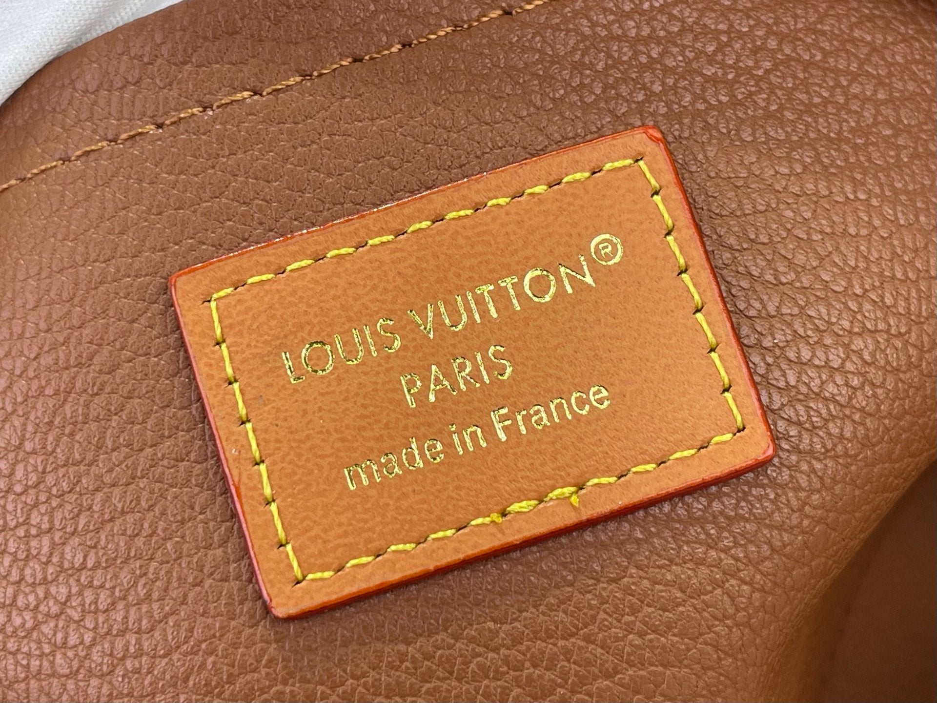 Louis Vuitton bag leather patch with neon yellow stitching, “Made in France” text