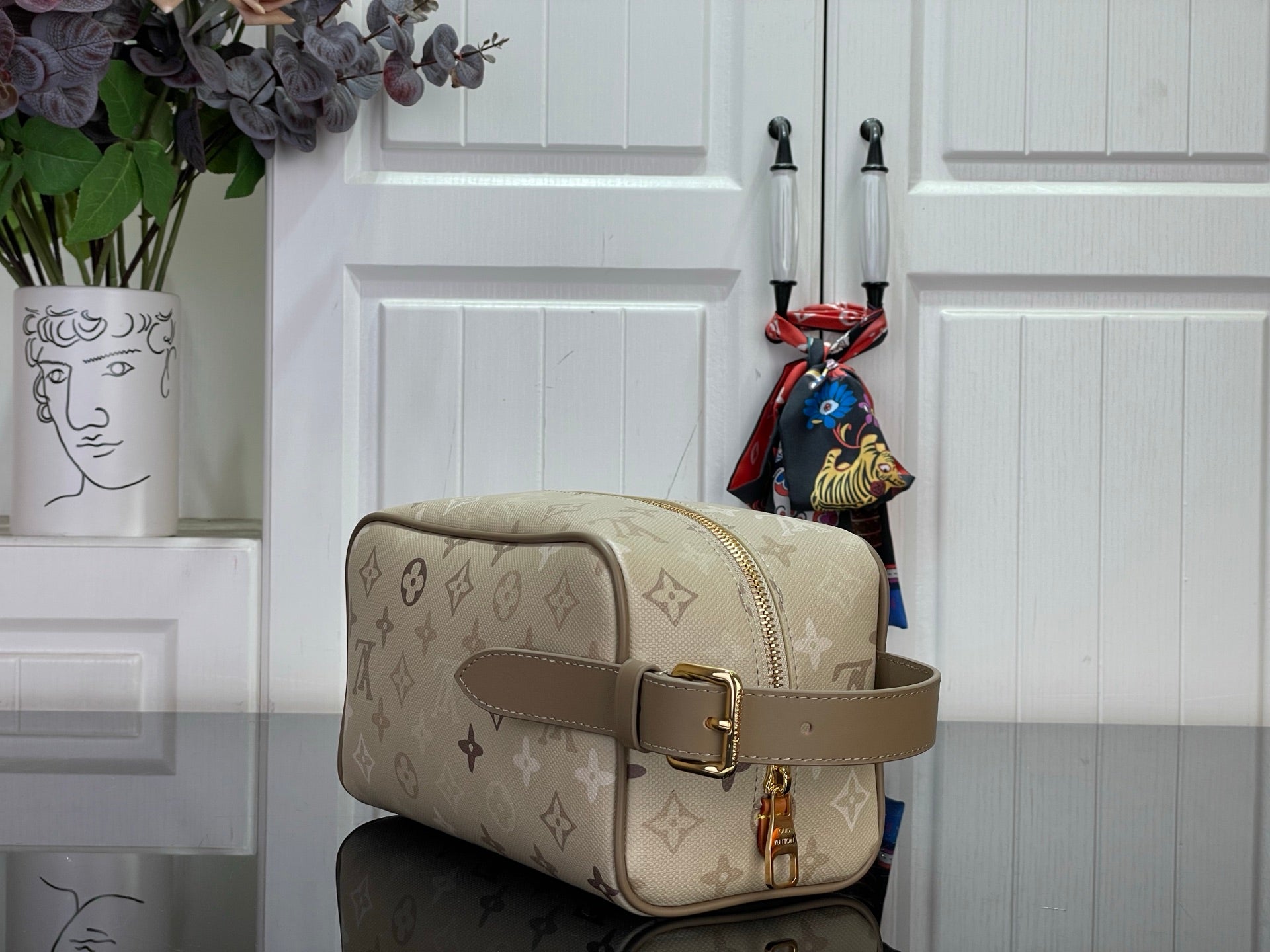 Louis Vuitton bag in beige monogram canvas, side view with adjustable leather strap and buckle