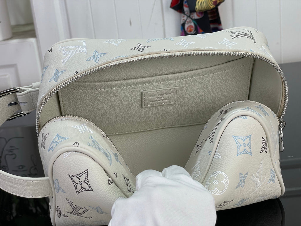 Open cream monogram bag showing interior lining and side pockets