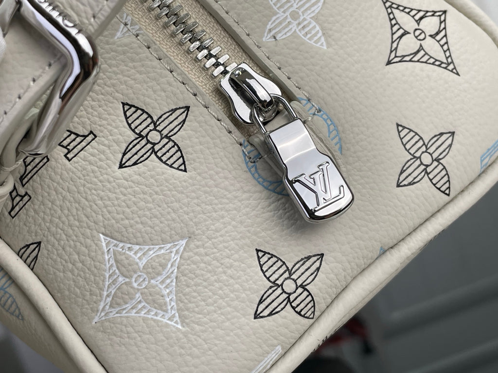 Silver zipper pull on cream monogram bag with blue bow pattern