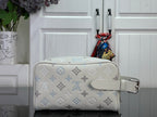 Cream monogram crossbody bag with blue print, adjustable strap, and silver buckle