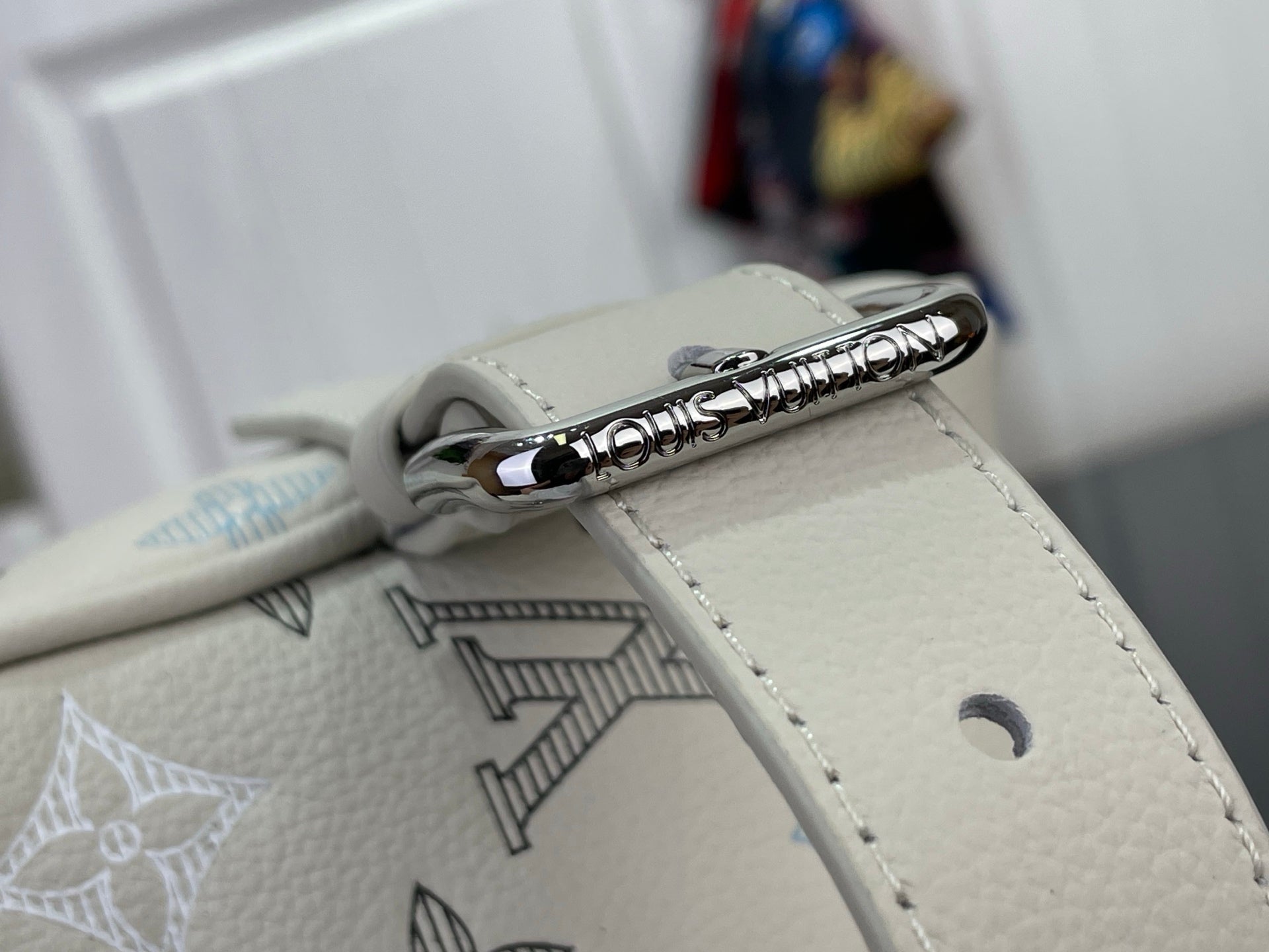 Cream leather bag zipper pull with silver ring and monogram-printed panel