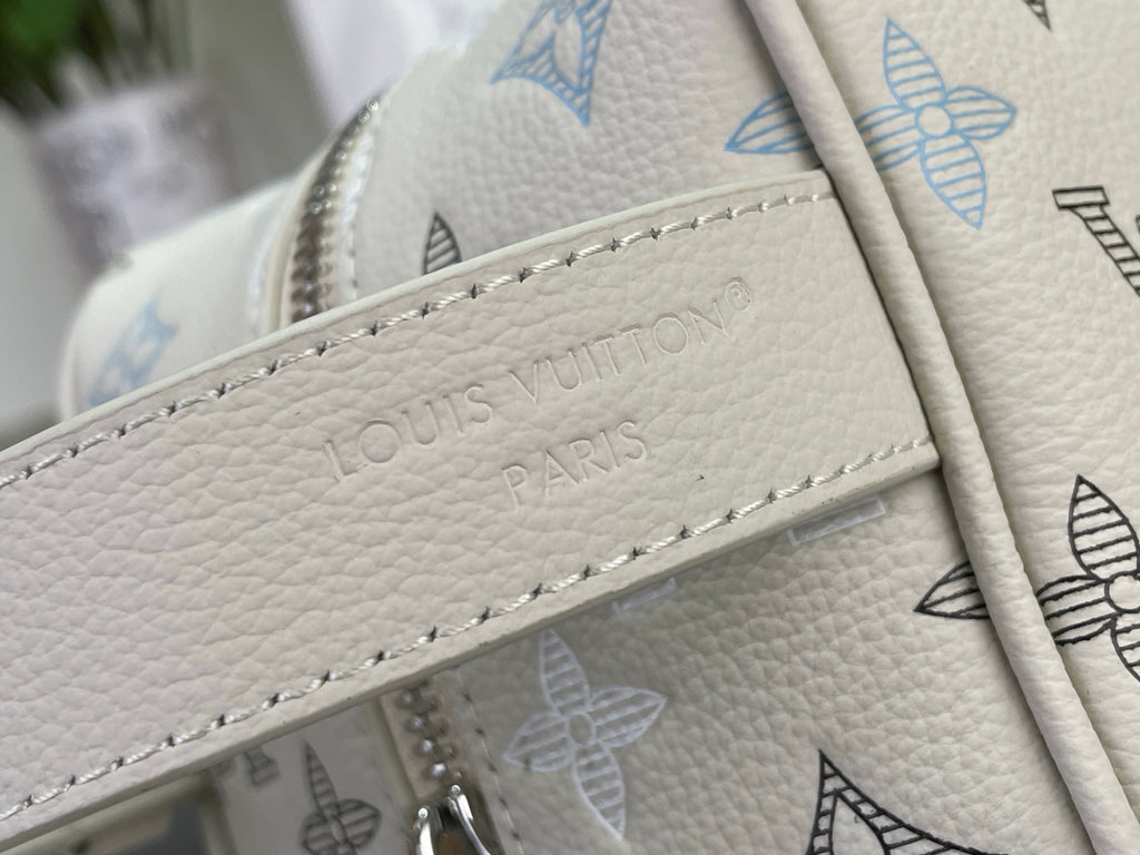 Embossed Louis Vuitton Paris logo plate on cream leather bag strap
