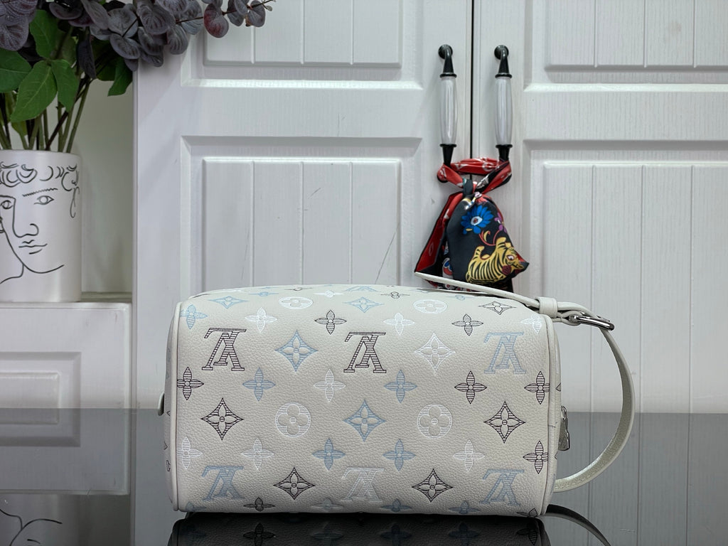 Cream monogram crossbody bag with blue pattern and top carry handle