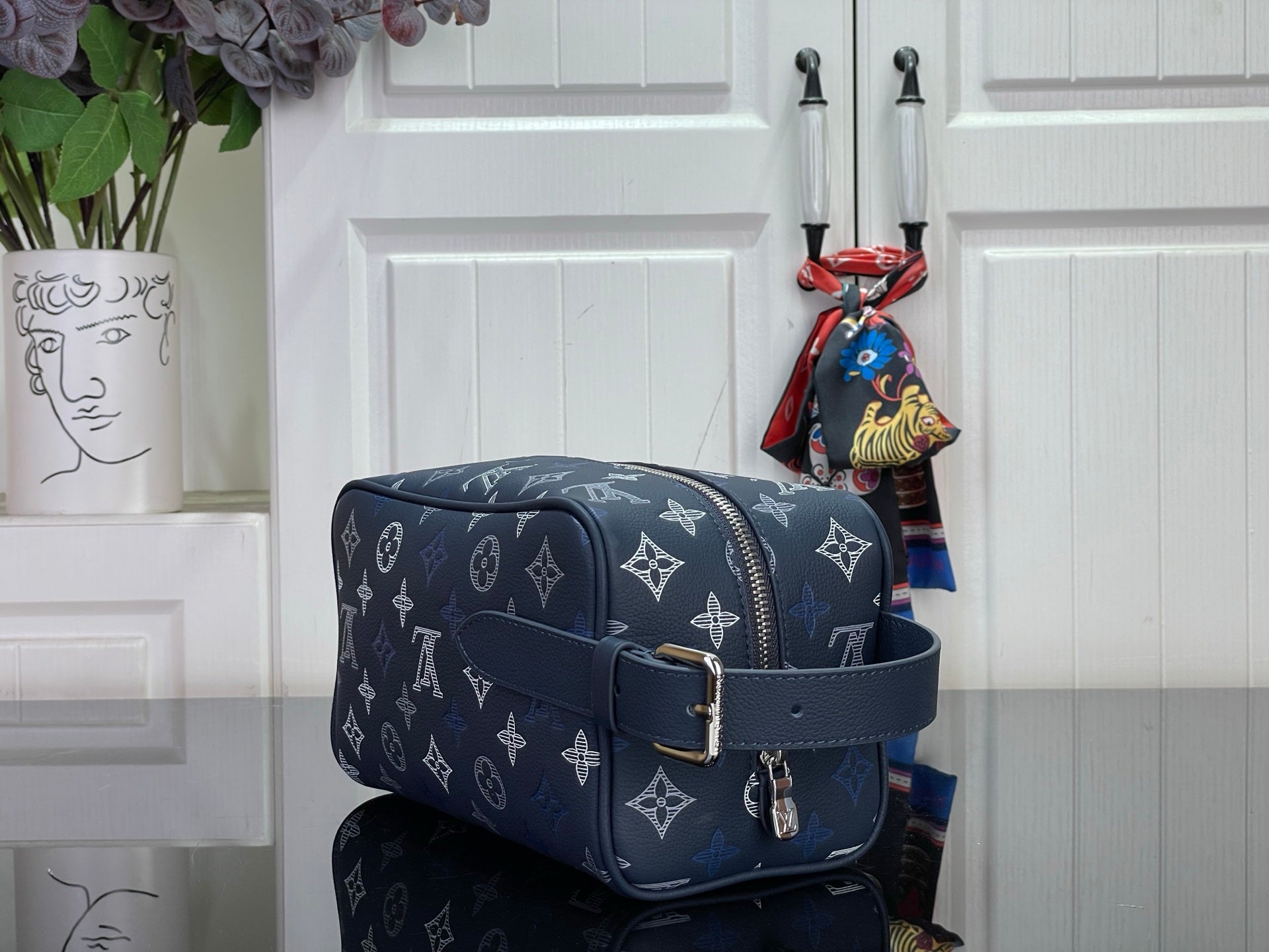 Louis Vuitton bag in dark navy with monogram, flap, crossbody strap, and silver buckle