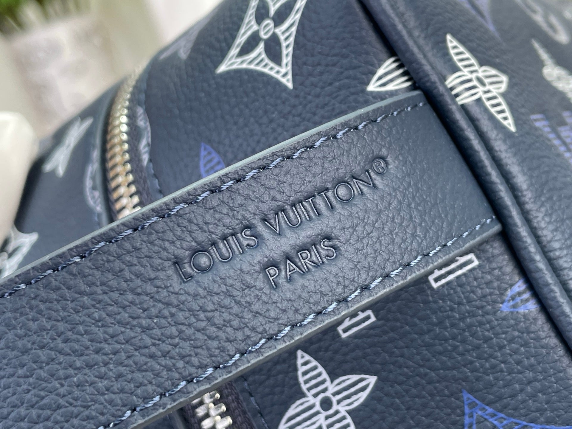 Louis Vuitton bag close-up of embossed logo on navy textured leather trim